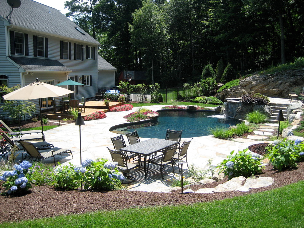 Foto di una piscina naturale tradizionale personalizzata di medie dimensioni e dietro casa con fontane e pavimentazioni in pietra naturale
