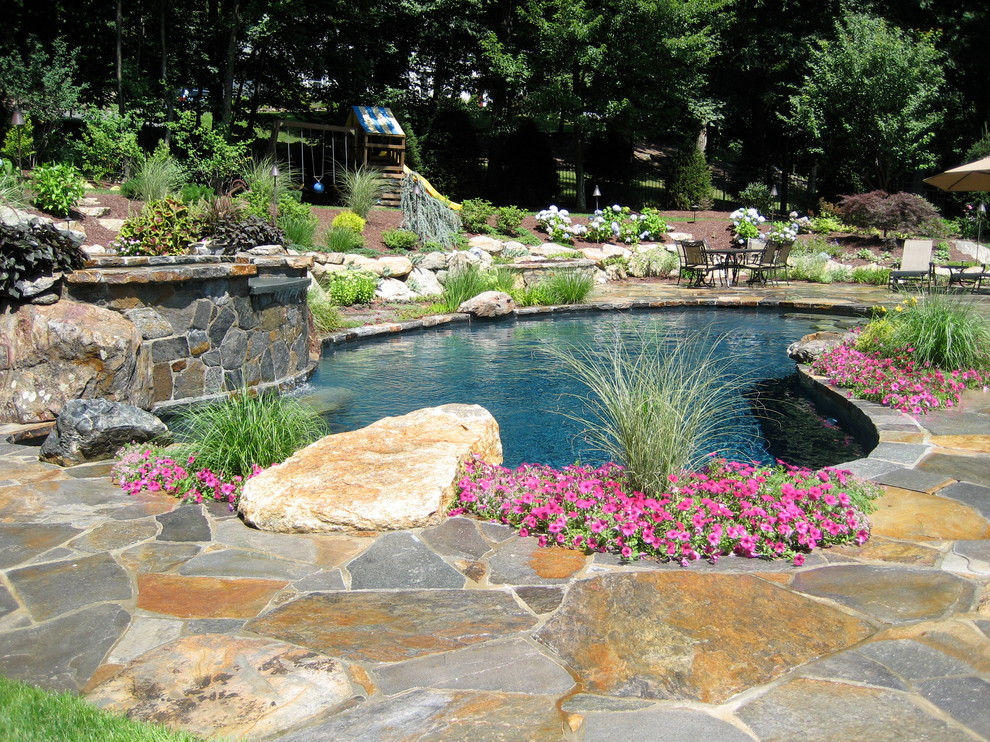 Mittelgroßer Klassischer Schwimmteich hinter dem Haus in individueller Form mit Wasserspiel und Natursteinplatten in New York