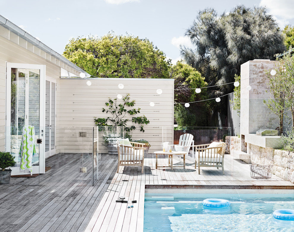 Cette photo montre une piscine arrière bord de mer de taille moyenne et rectangle avec une terrasse en bois.