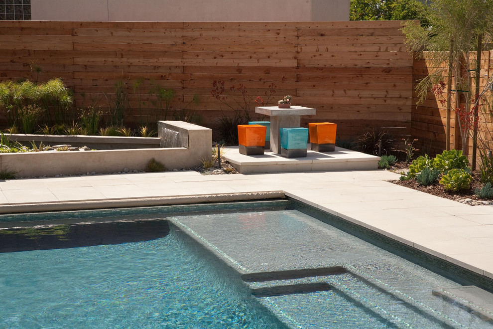 Foto di una piscina moderna rettangolare con pavimentazioni in cemento e una vasca idromassaggio
