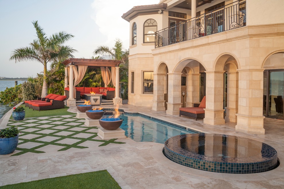 Kleiner Mediterraner Pool hinter dem Haus in rechteckiger Form mit Wasserspiel und Natursteinplatten in Tampa