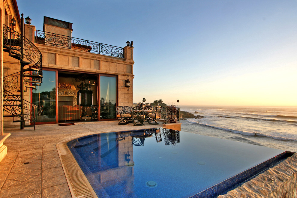 Idee per una piscina a sfioro infinito mediterranea rettangolare dietro casa e di medie dimensioni con piastrelle