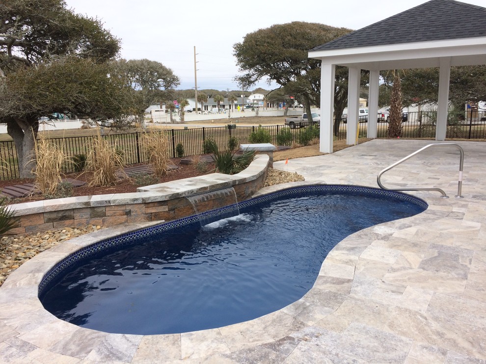 Esempio di una piscina stile marino rettangolare di medie dimensioni e dietro casa con fontane e pedane