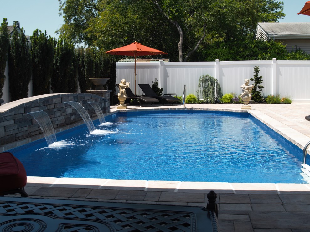 Pool fountain - mid-sized traditional backyard rectangular and stone lap pool fountain idea in New York