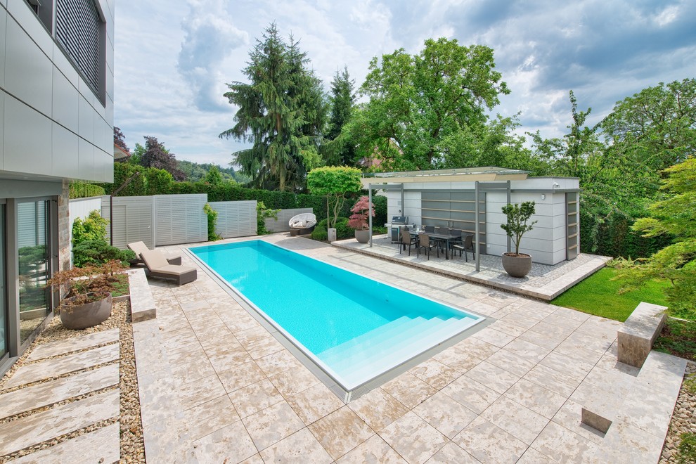 Idée de décoration pour une grande piscine hors-sol et arrière minimaliste rectangle avec des pavés en pierre naturelle.