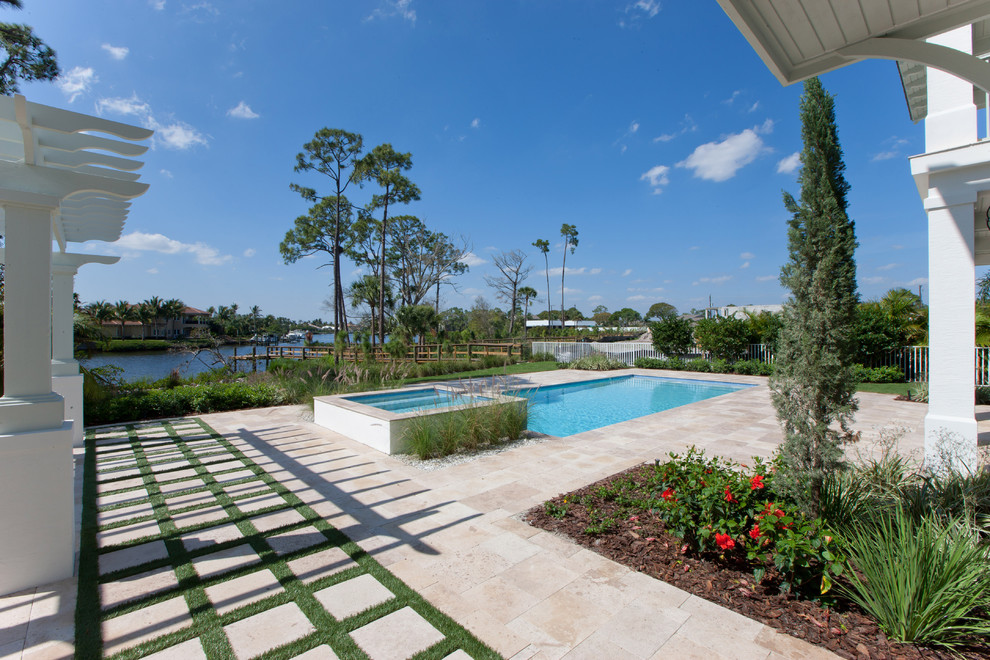 Inspiration for a large nautical back rectangular lengths swimming pool in Miami with a water feature and stamped concrete.