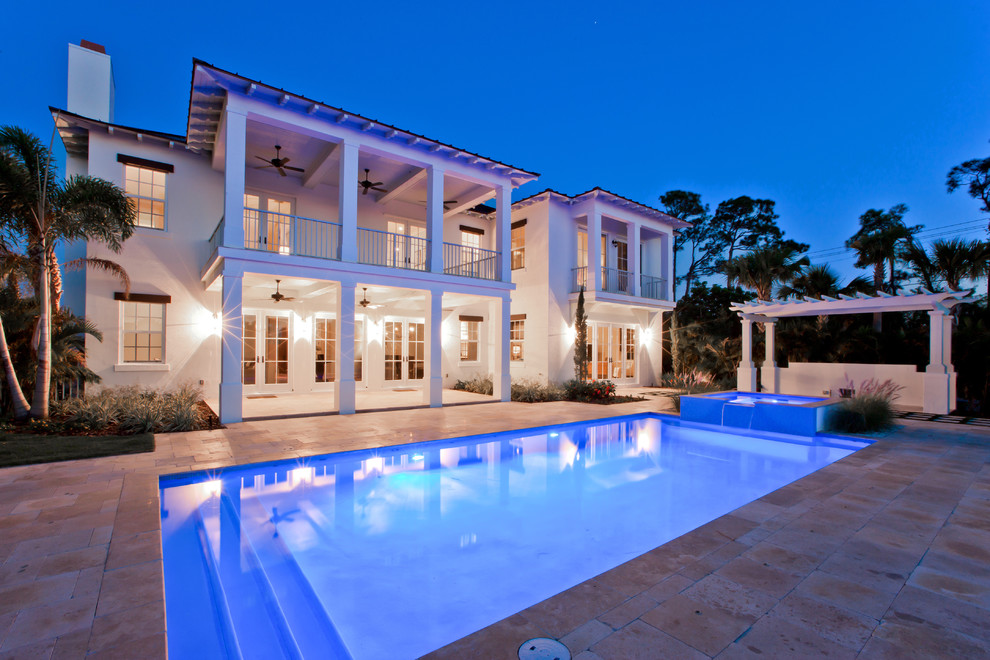Photo of a large coastal back rectangular lengths swimming pool in Miami with a water feature and stamped concrete.