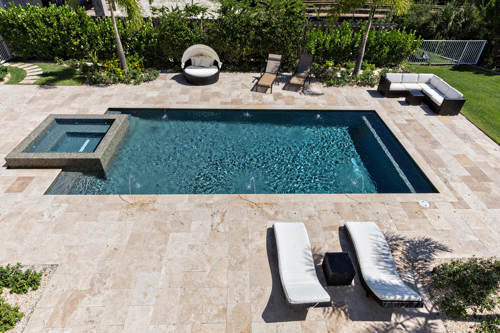 На фото: большой прямоугольный бассейн на заднем дворе в современном стиле с джакузи и покрытием из плитки