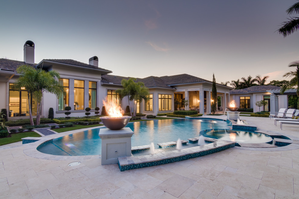 Photo of a mediterranean custom shaped swimming pool in Miami with a water feature.
