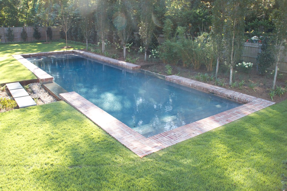 Diseño de piscinas y jacuzzis alargados tradicionales de tamaño medio rectangulares en patio trasero con adoquines de ladrillo