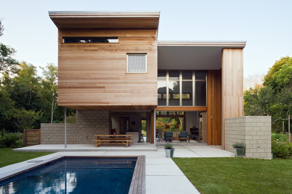 Foto di una piscina monocorsia minimal rettangolare di medie dimensioni e dietro casa con lastre di cemento