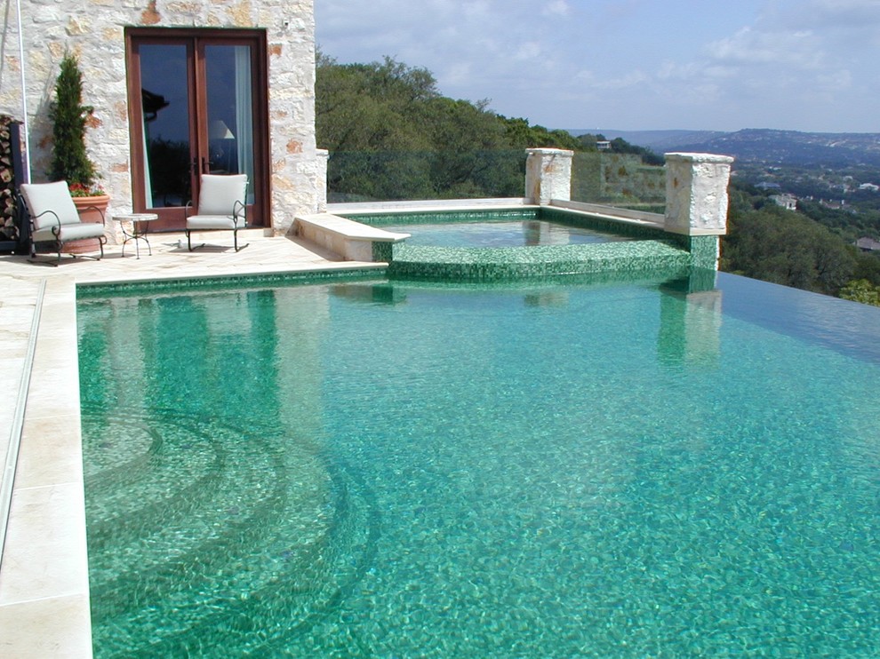 Inspiration for a mid-sized mediterranean backyard concrete and rectangular infinity hot tub remodel in Austin