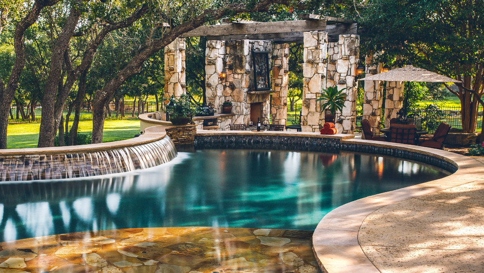 Medium sized traditional back custom shaped natural swimming pool in Austin with concrete slabs and a bar area.