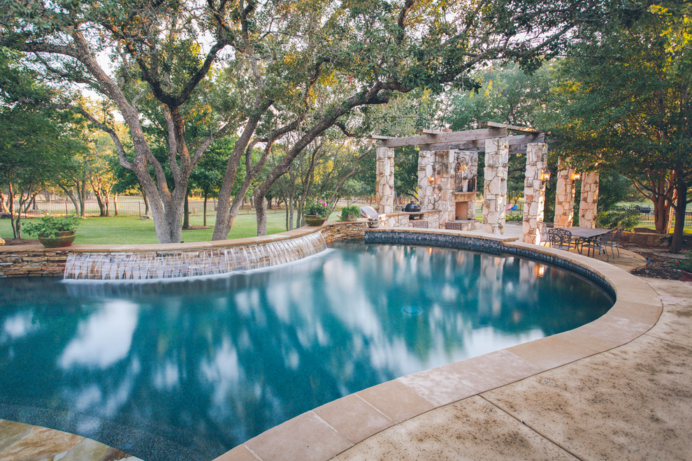 Esempio di una piscina naturale chic personalizzata di medie dimensioni e dietro casa con lastre di cemento