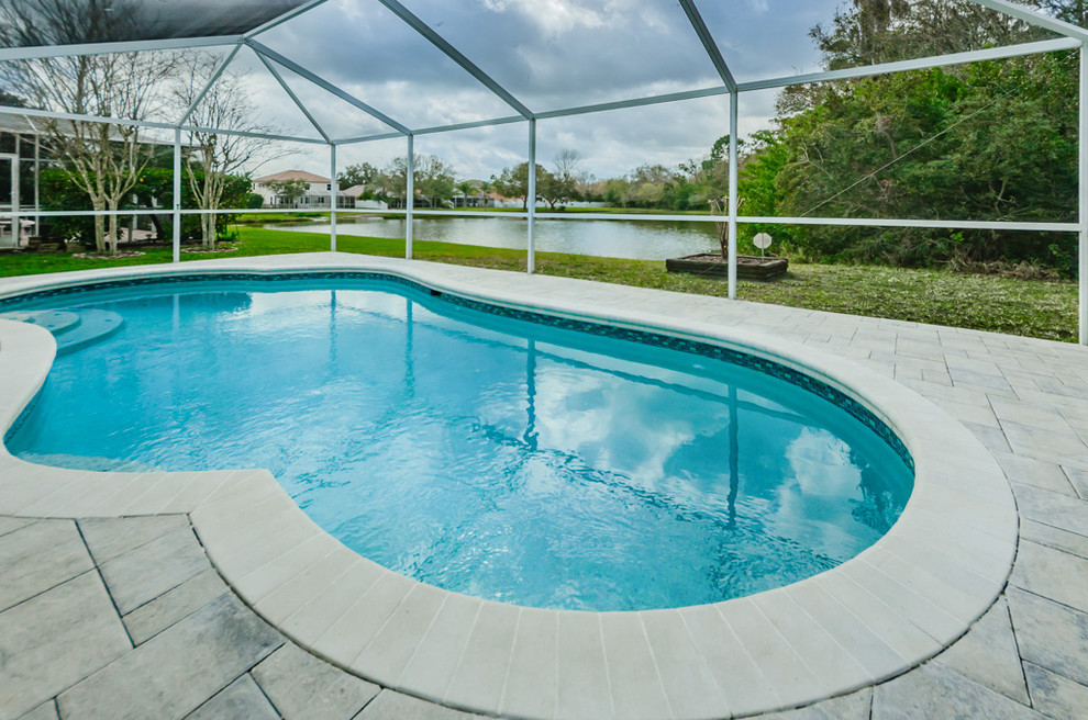 Esempio di una piscina naturale stile marinaro a "C" di medie dimensioni e dietro casa con pedane