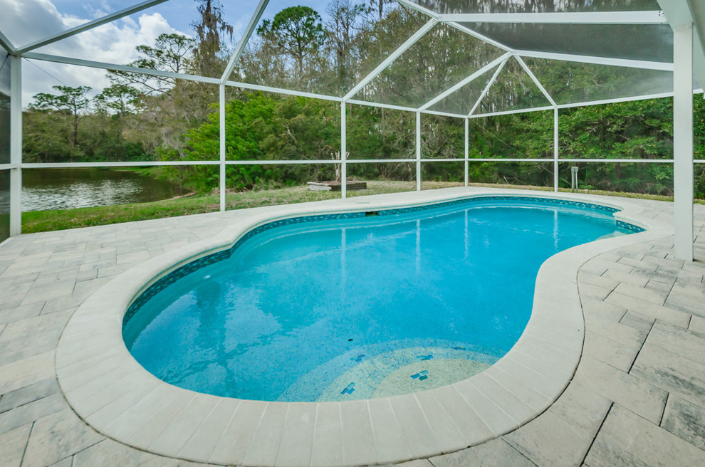 Exemple d'une piscine naturelle et arrière bord de mer en forme de haricot de taille moyenne avec une terrasse en bois.