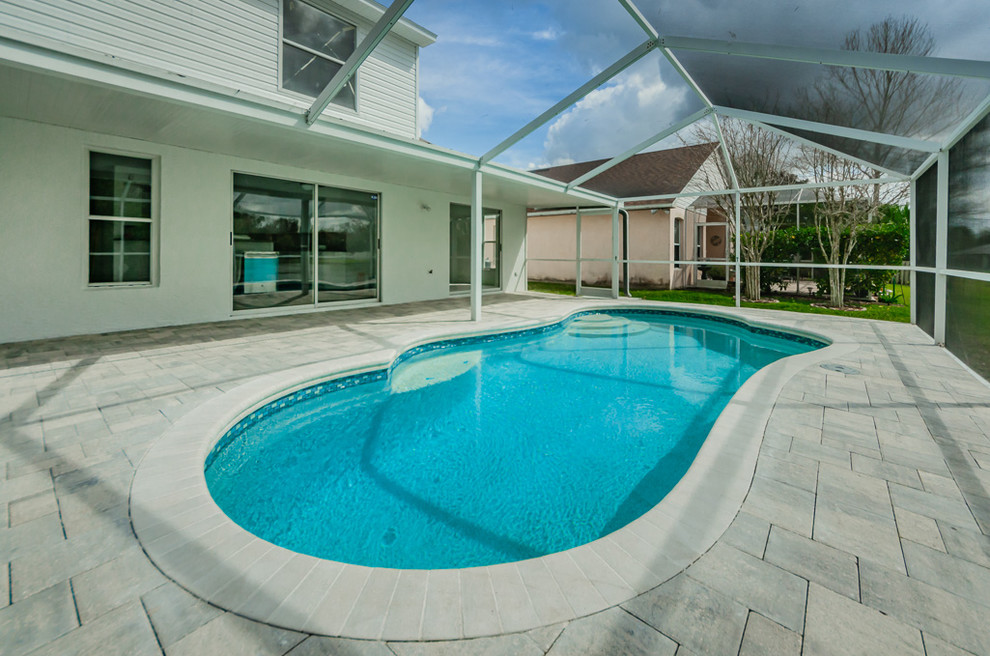 Diseño de piscina natural costera de tamaño medio tipo riñón en patio trasero con entablado