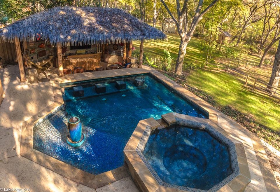 Foto di una grande piscina monocorsia tropicale personalizzata dietro casa con una vasca idromassaggio