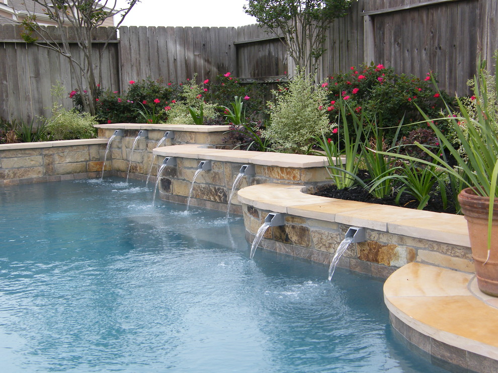 Example of a mid-sized transitional backyard tile and custom-shaped pool fountain design in Houston