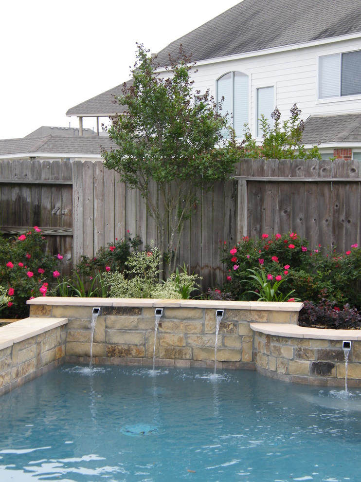 Modelo de piscina con fuente clásica renovada de tamaño medio a medida en patio trasero con suelo de baldosas