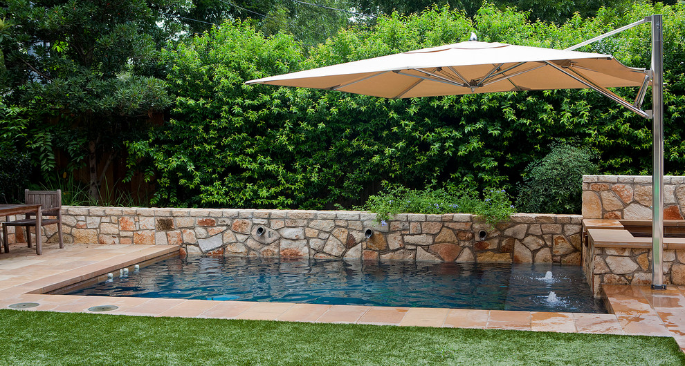 Ispirazione per una piccola piscina monocorsia chic rettangolare dietro casa con pavimentazioni in pietra naturale e una vasca idromassaggio