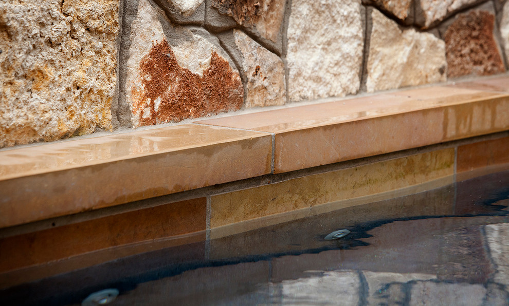 Foto de piscinas y jacuzzis alargados tradicionales pequeños rectangulares en patio trasero con adoquines de piedra natural