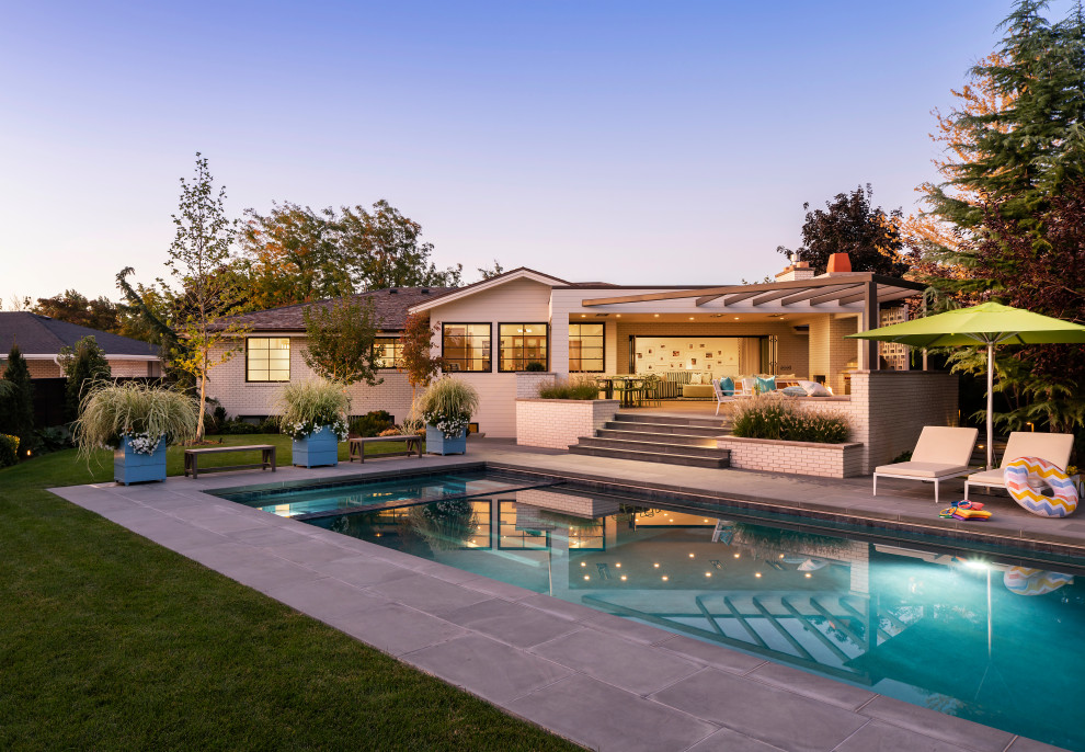 Стильный дизайн: прямоугольный бассейн среднего размера на заднем дворе в стиле неоклассика (современная классика) с покрытием из плитки - последний тренд