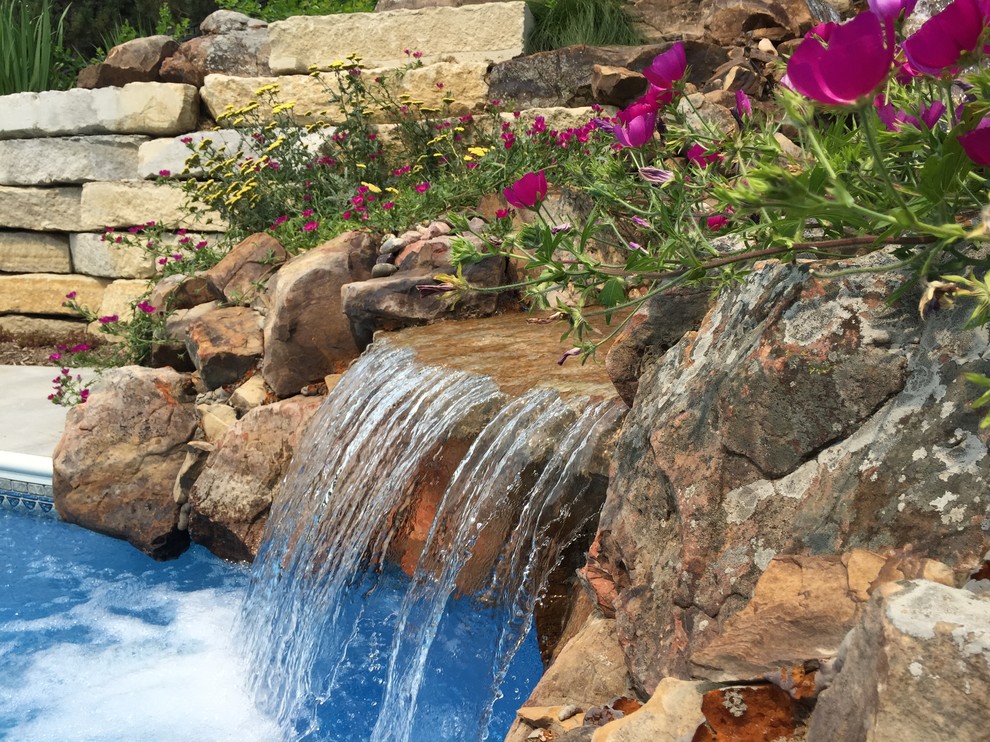 This is an example of a large back swimming pool in Omaha with a water feature.
