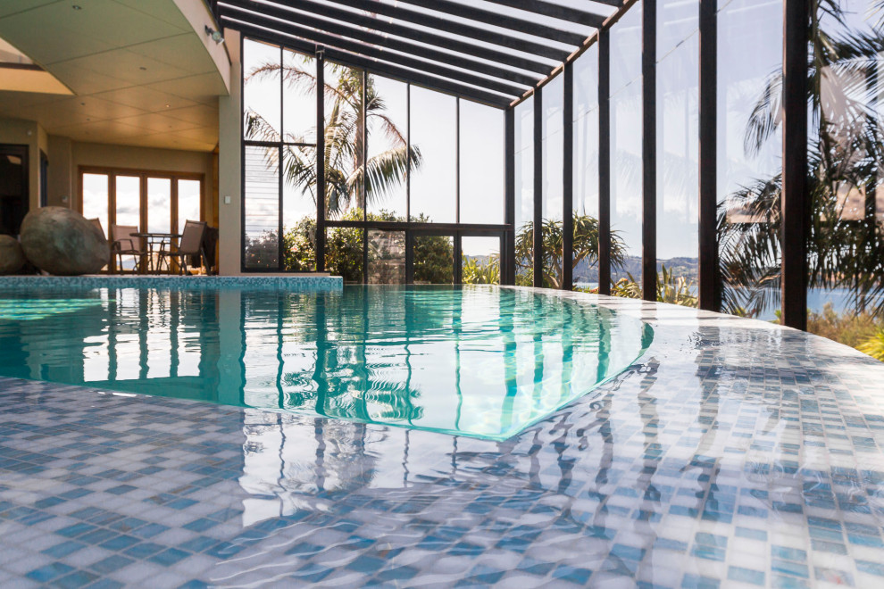 Ispirazione per una grande piscina coperta a sfioro infinito minimal personalizzata con piastrelle