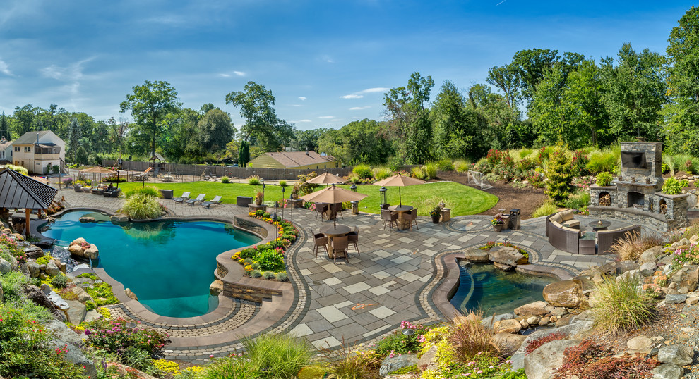 Imagen de piscinas y jacuzzis naturales extra grandes a medida en patio trasero con adoquines de hormigón
