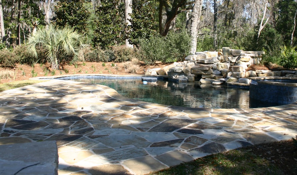 На фото: естественный бассейн среднего размера, произвольной формы на заднем дворе в современном стиле с домиком у бассейна и покрытием из каменной брусчатки с