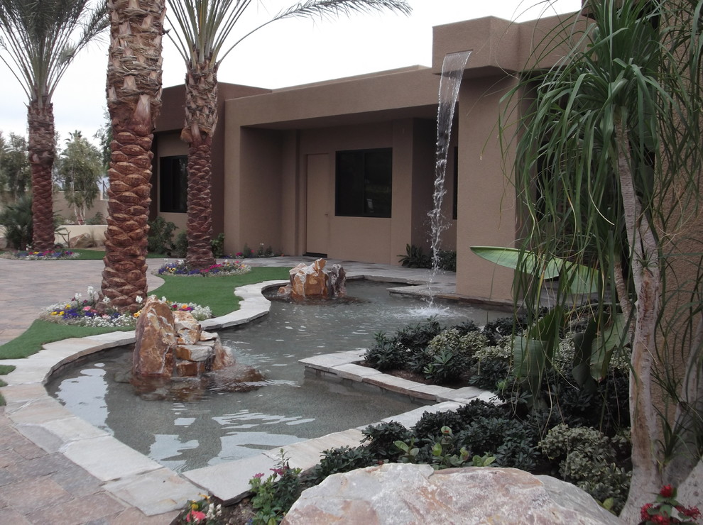 Aménagement d'un couloir de nage avant exotique de taille moyenne et sur mesure avec un point d'eau et des pavés en pierre naturelle.