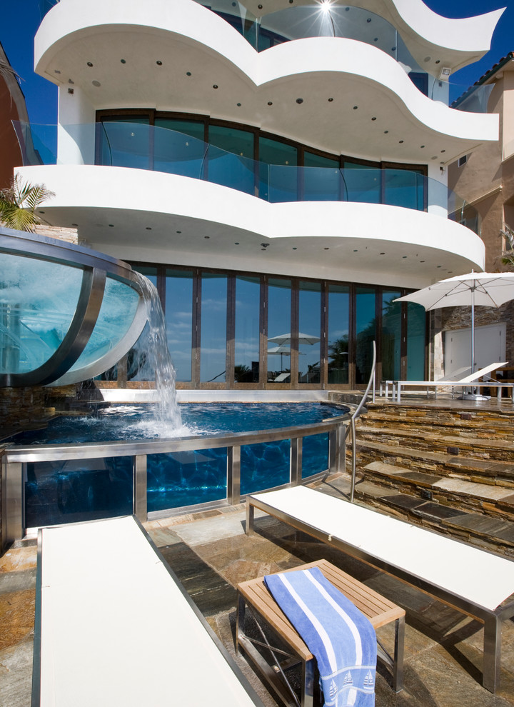 Идея дизайна: большой бассейн произвольной формы на заднем дворе в современном стиле с покрытием из каменной брусчатки