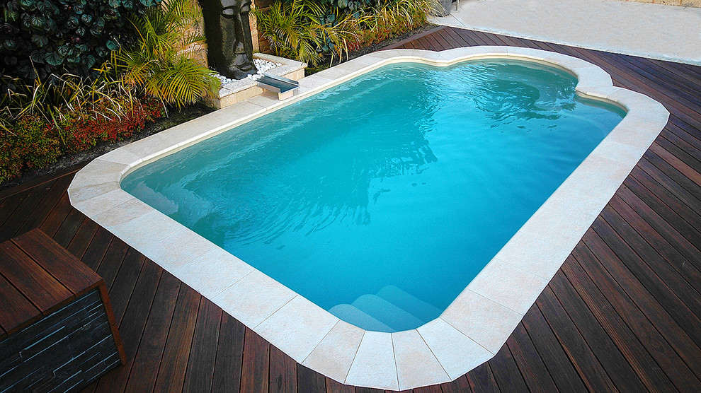 На фото: маленький прямоугольный бассейн на заднем дворе в современном стиле с фонтаном и настилом для на участке и в саду с