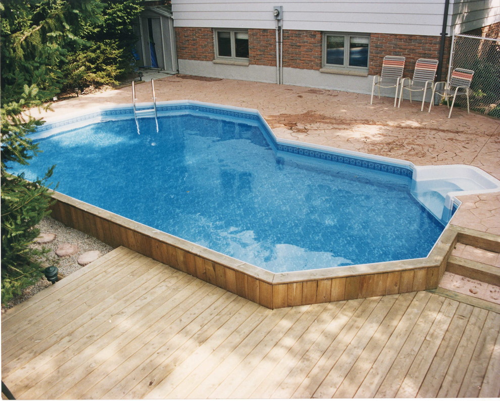 Idée de décoration pour une piscine arrière tradition de taille moyenne et sur mesure avec des pavés en béton.