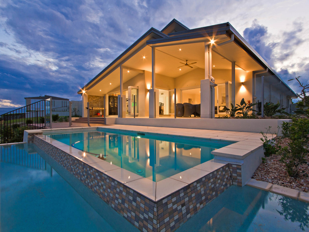 Esempio di una piscina a sfioro infinito stile marinaro personalizzata di medie dimensioni e dietro casa con piastrelle