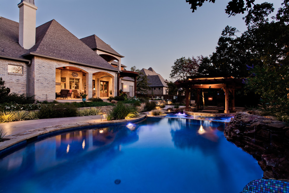 Diseño de piscina natural exótica extra grande a medida en patio trasero con adoquines de piedra natural