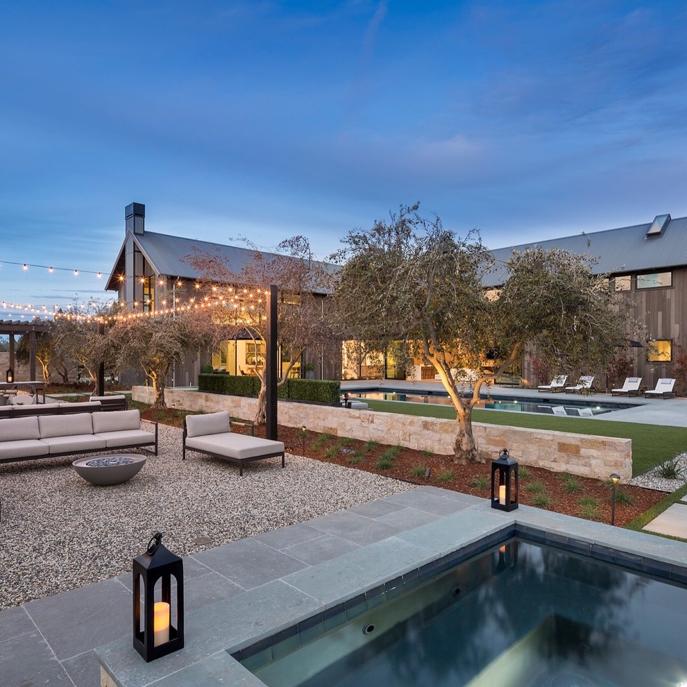 Diseño de casa de la piscina y piscina alargada actual extra grande rectangular en patio trasero con losas de hormigón
