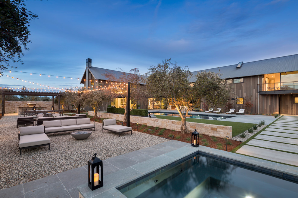 Photo of an expansive contemporary back rectangular lengths hot tub in San Francisco with natural stone paving.