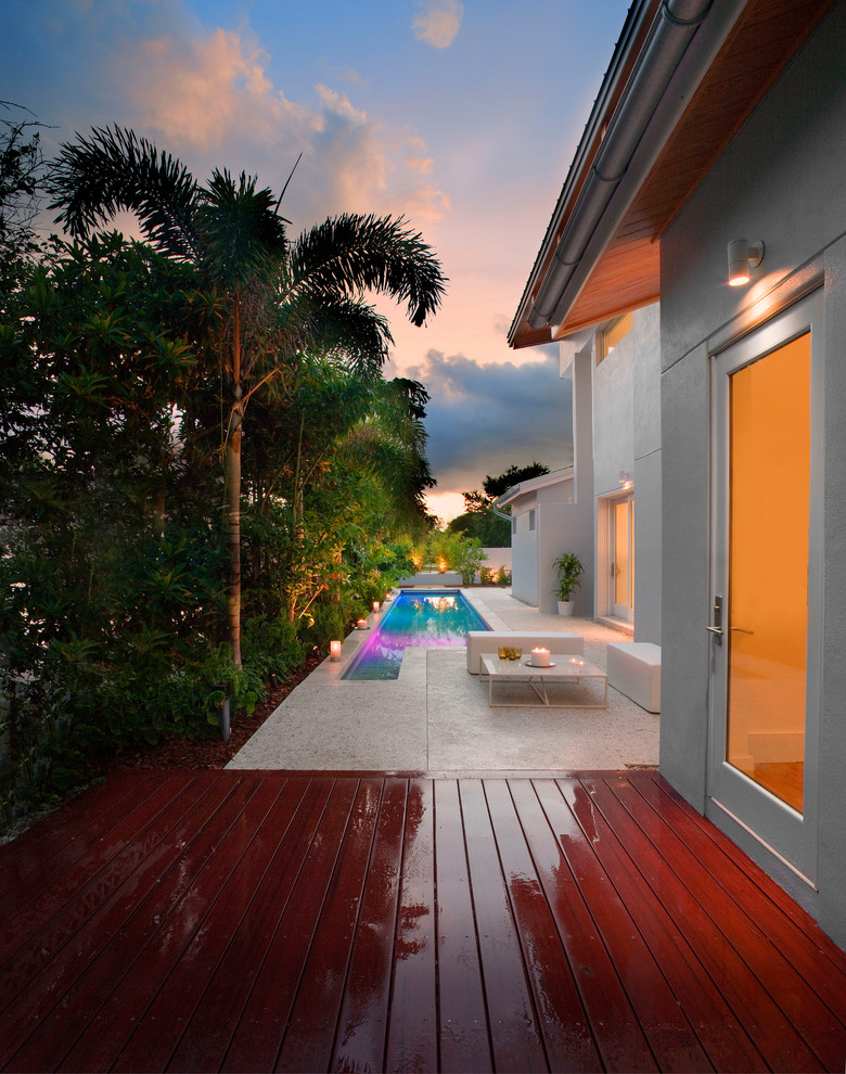 Idée de décoration pour un couloir de nage arrière design de taille moyenne et rectangle avec une terrasse en bois.