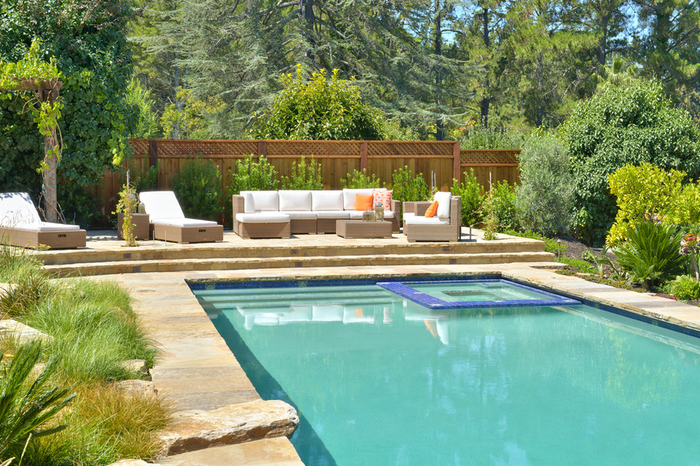 Idee per una piscina monocorsia mediterranea rettangolare di medie dimensioni e dietro casa con una vasca idromassaggio e pavimentazioni in pietra naturale