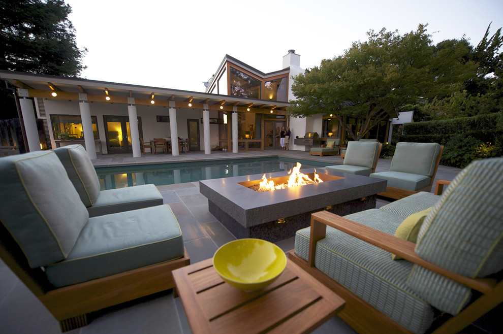 This is an example of a contemporary back rectangular lengths swimming pool in San Francisco with natural stone paving.
