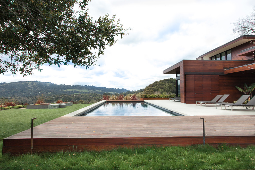 Foto de piscina con fuente minimalista en patio trasero con entablado