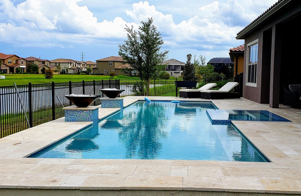 Idee per una piscina monocorsia moderna rettangolare di medie dimensioni e dietro casa con una vasca idromassaggio e pavimentazioni in pietra naturale