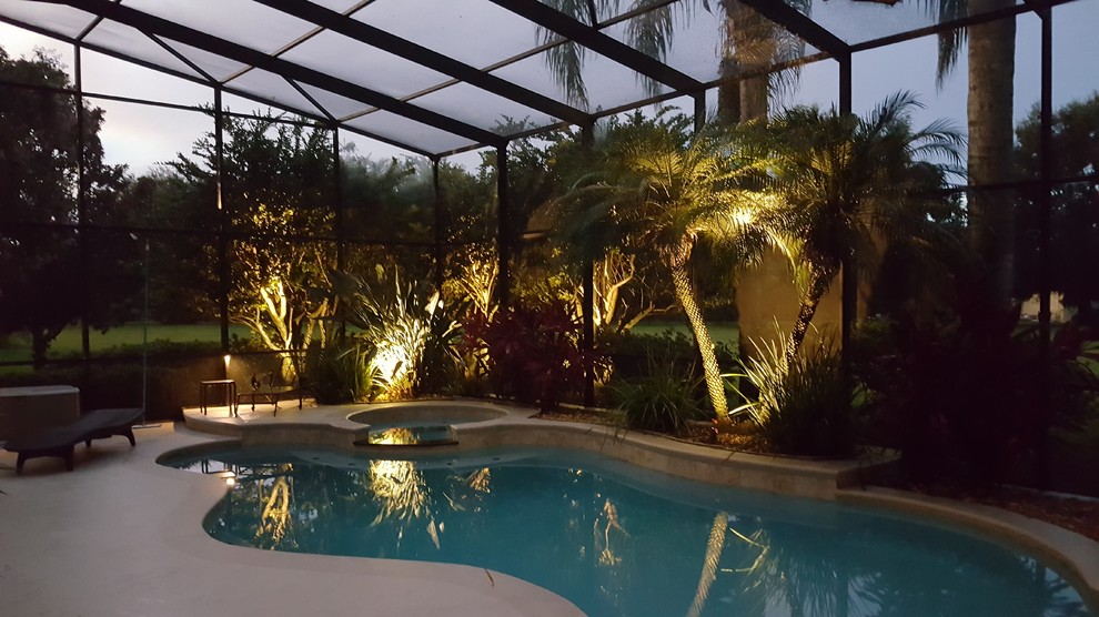 Diseño de casa de la piscina y piscina natural exótica de tamaño medio a medida en patio trasero con losas de hormigón