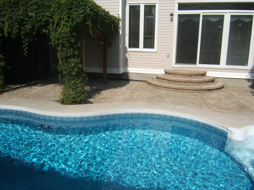 Pool - mid-sized backyard concrete paver and custom-shaped pool idea in Ottawa