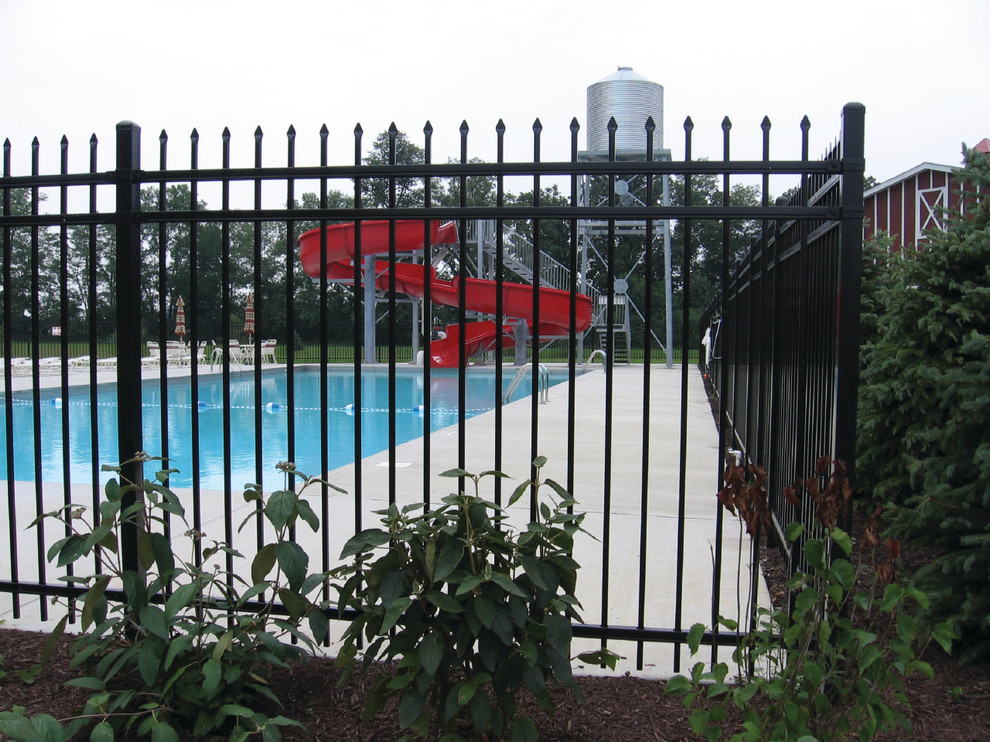 Ispirazione per un'ampia piscina monocorsia classica rettangolare dietro casa con un acquascivolo e lastre di cemento