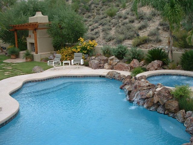 Réalisation d'une piscine arrière design en forme de haricot de taille moyenne avec un point d'eau et une dalle de béton.