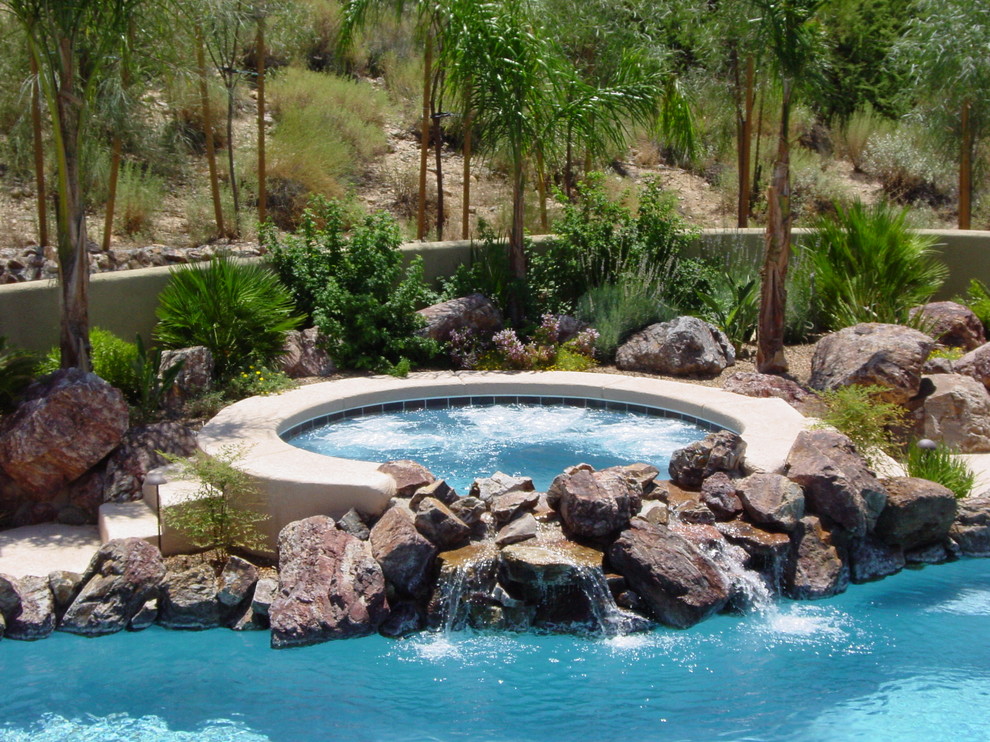 Mittelgroßer Moderner Pool hinter dem Haus in Nierenform mit Wasserspiel und Betonplatten in Phoenix