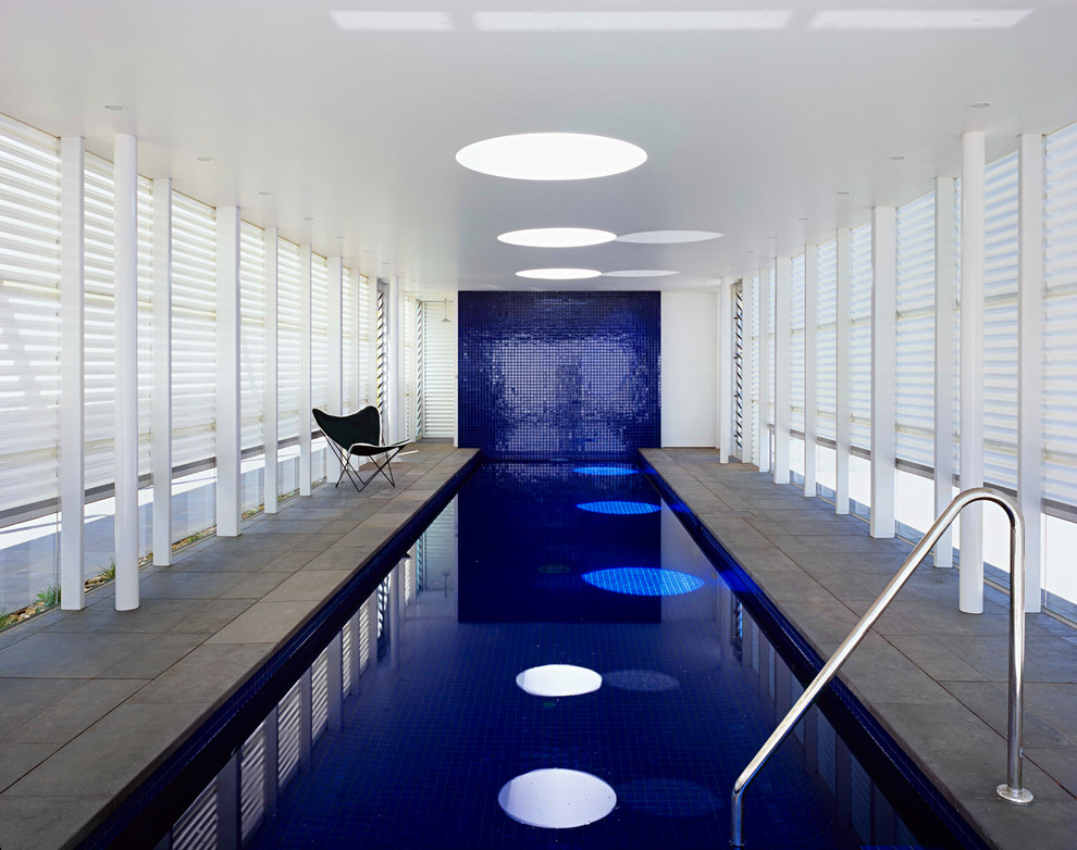Large contemporary indoor rectangular swimming pool in Melbourne with natural stone paving.